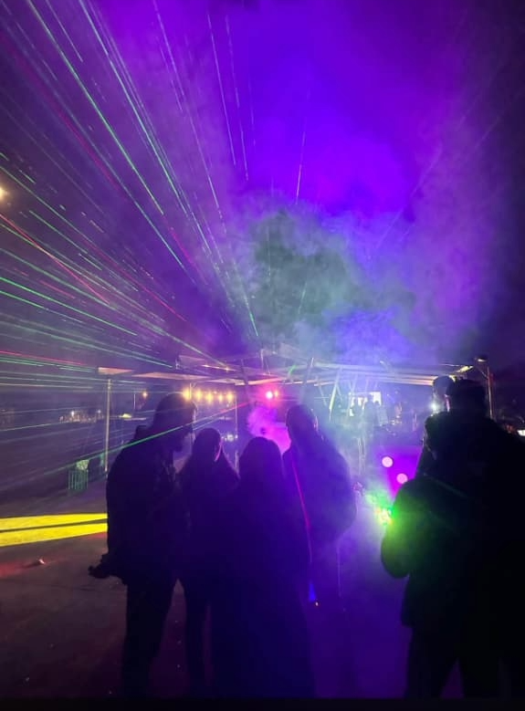 Laser beams cutting through haze over a crowd